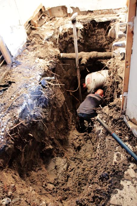 Floor opened inside a Tampa house down to a root filled trench at the drain line